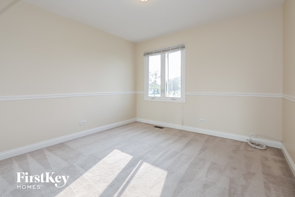 an empty room with white walls and a window