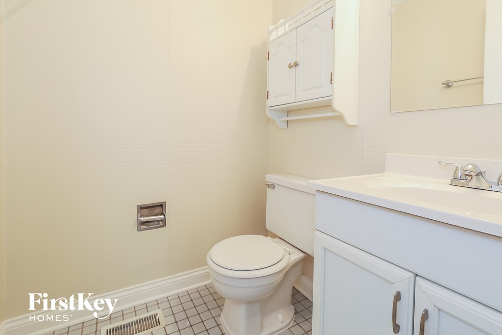 a white bathroom with a toilet and a sink