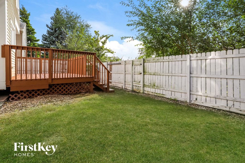 a fisheye view of a backyard with a deck and a white fence