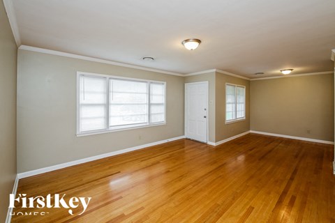 a living room with wood floors and a white door and window