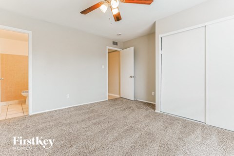 a bedroom with a carpeted floor and a ceiling fan