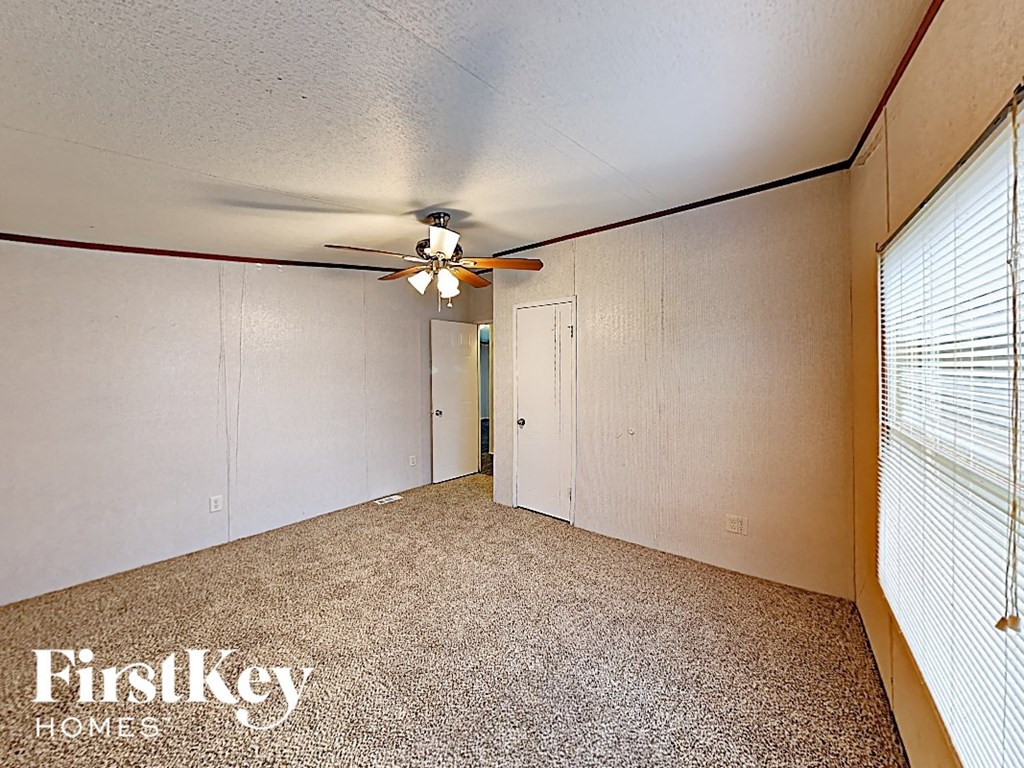 the living room of an empty house with a ceiling fan
