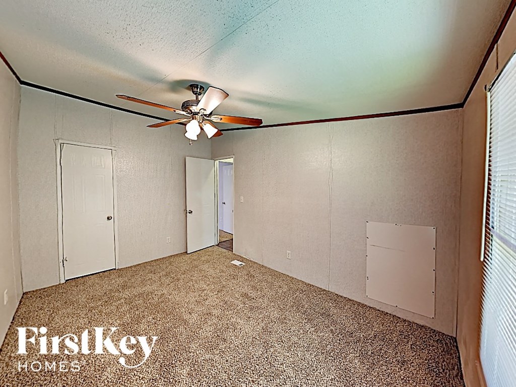 the bonus room has a ceiling fan and a closet