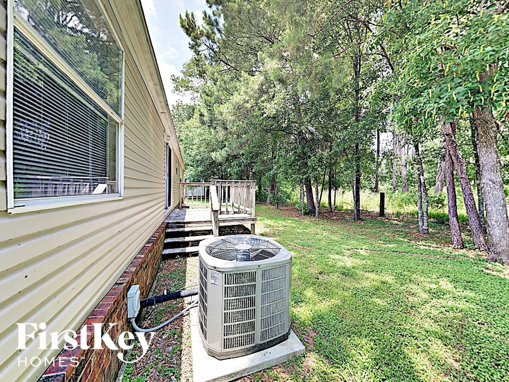 the side of a house with a heating unit in the yard