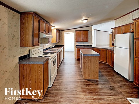 a large kitchen with wooden cabinets and white appliances
