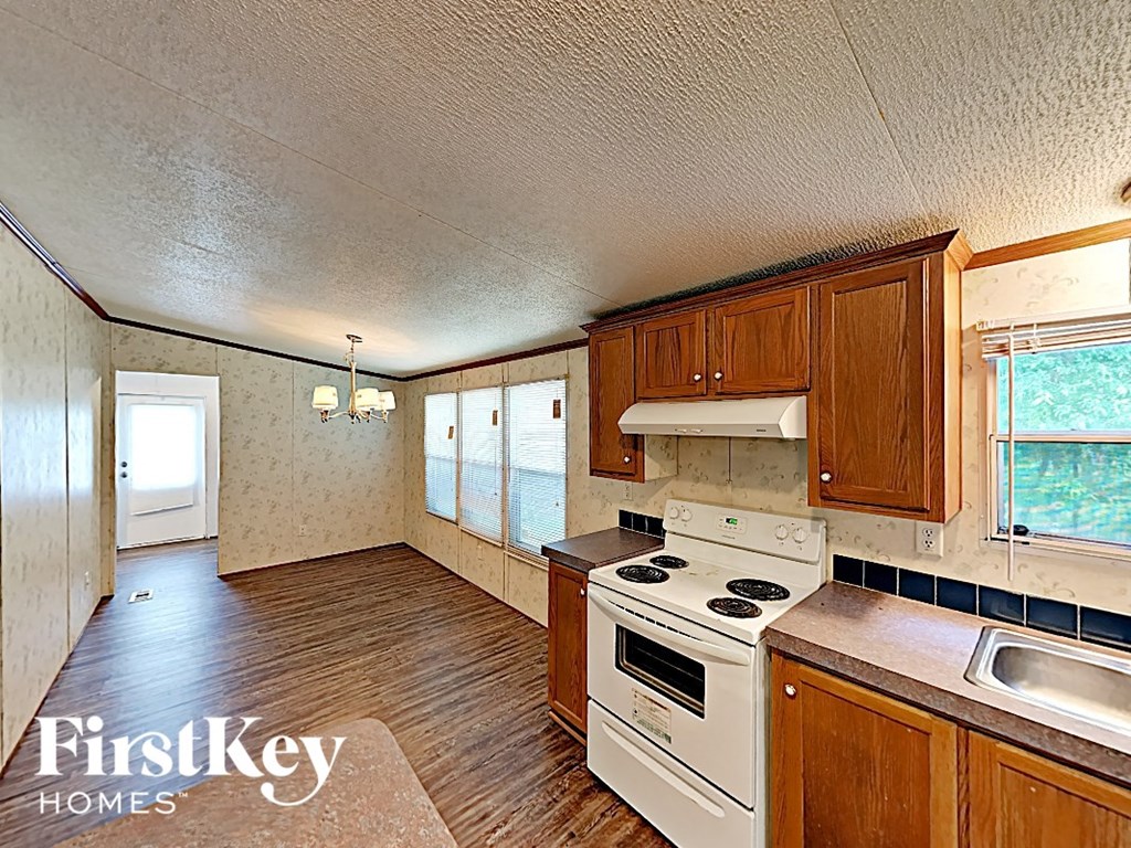 an empty kitchen with a stove and a sink