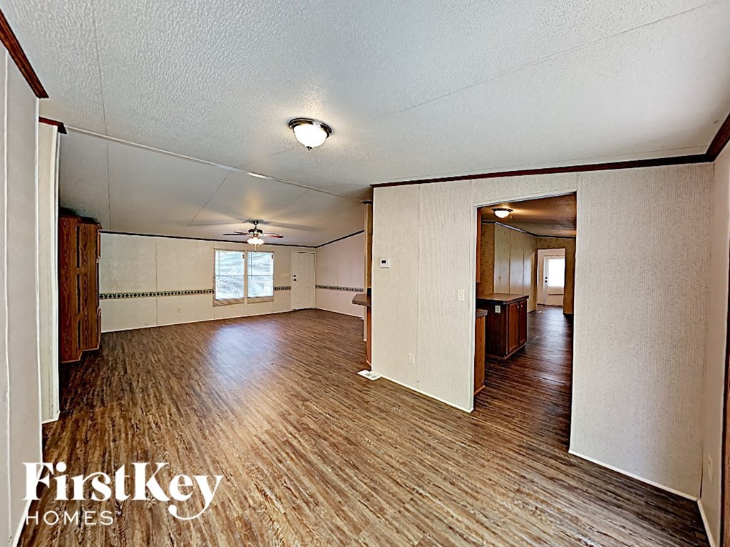 an empty living room and dining room with wood flooring
