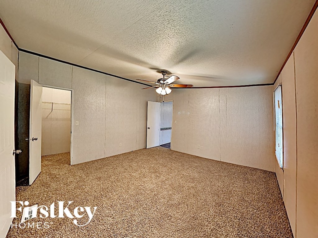 the living room of an empty house with a ceiling fan