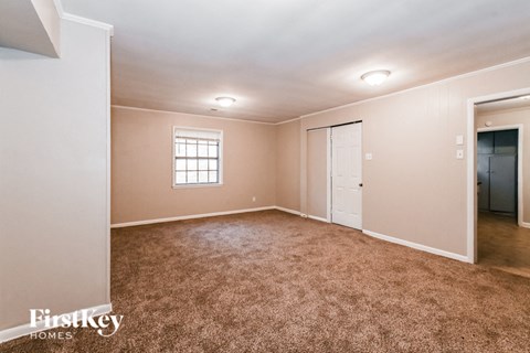 a master bedroom with carpet and a door to a closet