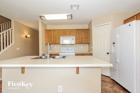 A kitchen with a white counter top and wooden cabinets.