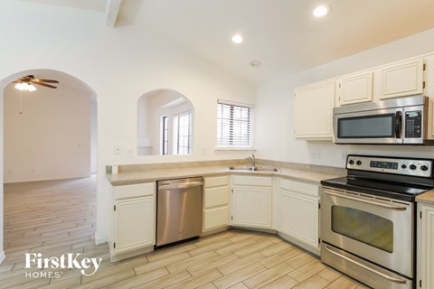 A kitchen with a stove top oven and a microwave above the sink.