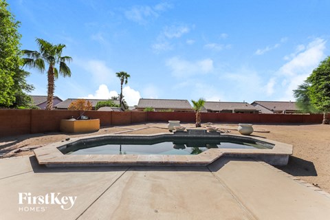 a hot tub in the backyard of a house with palm trees