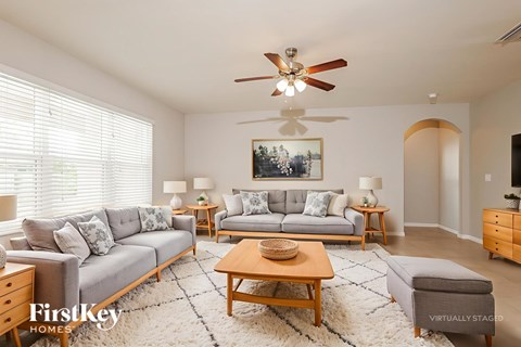 A living room with a grey couch, a wooden coffee table, and a painting on the wall.
