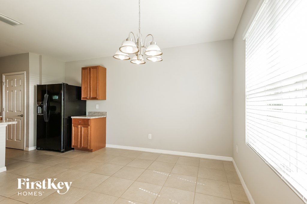 A kitchen with a black fridge and wooden cabinets.
