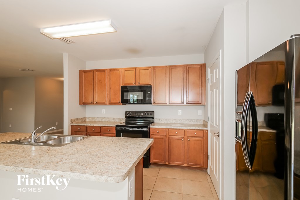 A kitchen with wooden cabinets and a granite countertop.