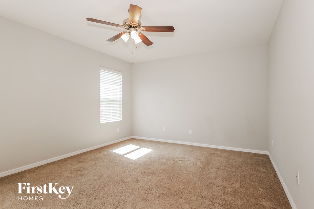 A room with a ceiling fan and a window.