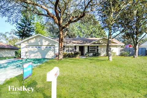 a house with a yard and a pool in front of it