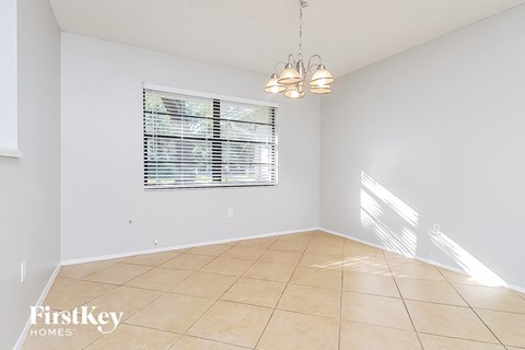 an empty living room with a window and a tiled floor