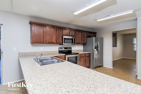 a kitchen with a granite counter top and a stainless steel refrigerator