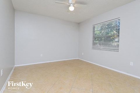 the living room of an empty house with a ceiling fan