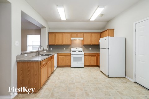 A kitchen with wooden cabinets and a white refrigerator.