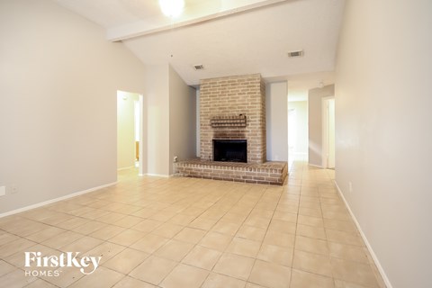A spacious living room with a fireplace and tiled flooring.