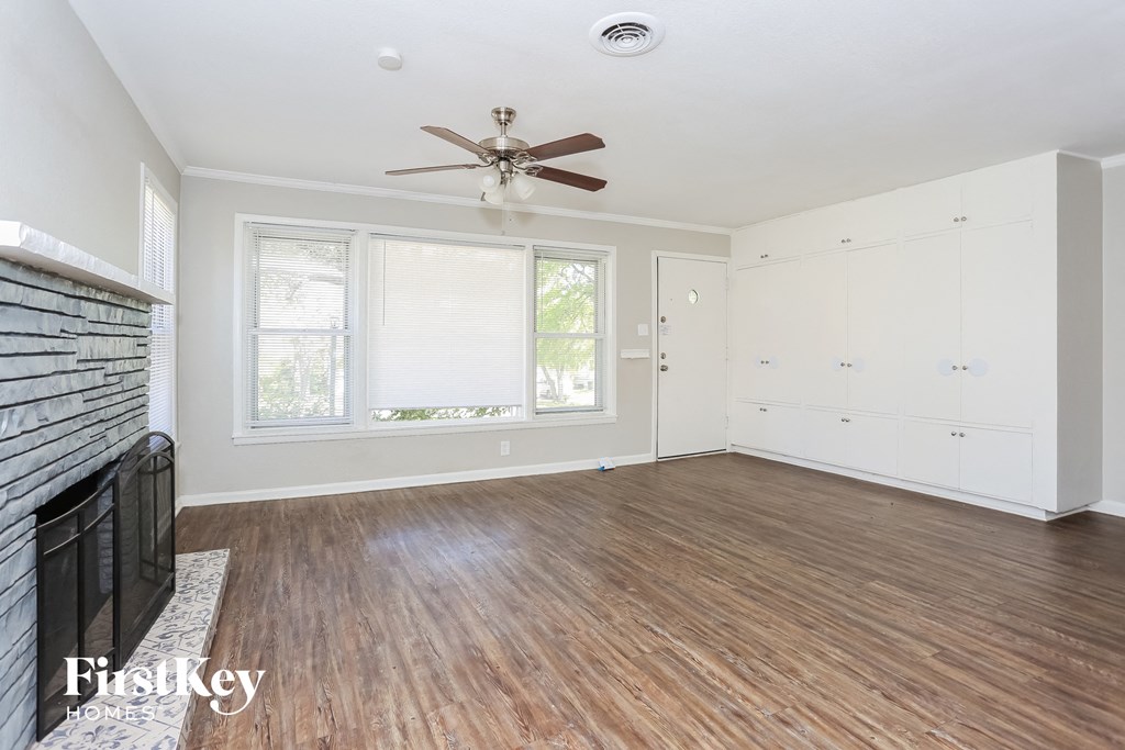 a living room with wood floors and a ceiling fan