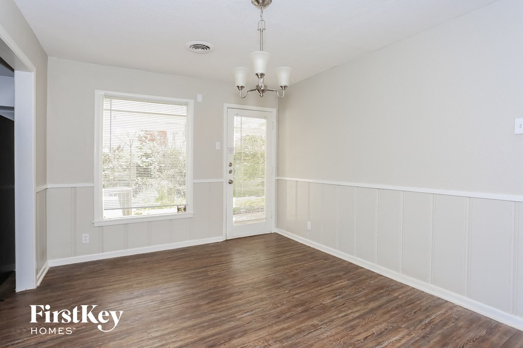 the living room of a home with wood floors and white walls
