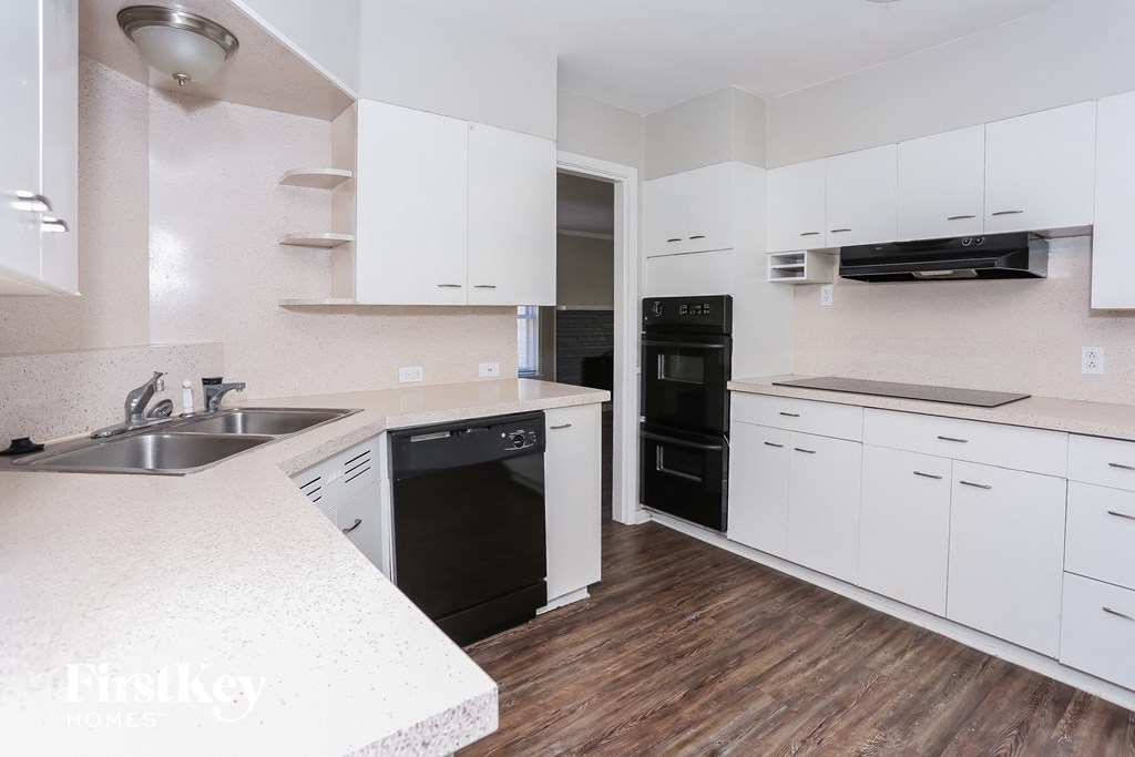 a white kitchen with black appliances and white cabinets