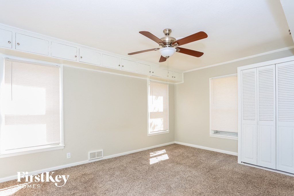 a living room with a ceiling fan and two windows