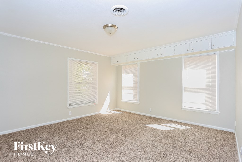 a bedroom with a carpeted floor and two windows