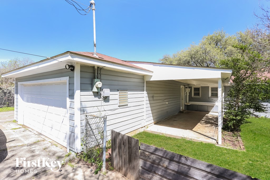 a small white house with a porch and a driveway