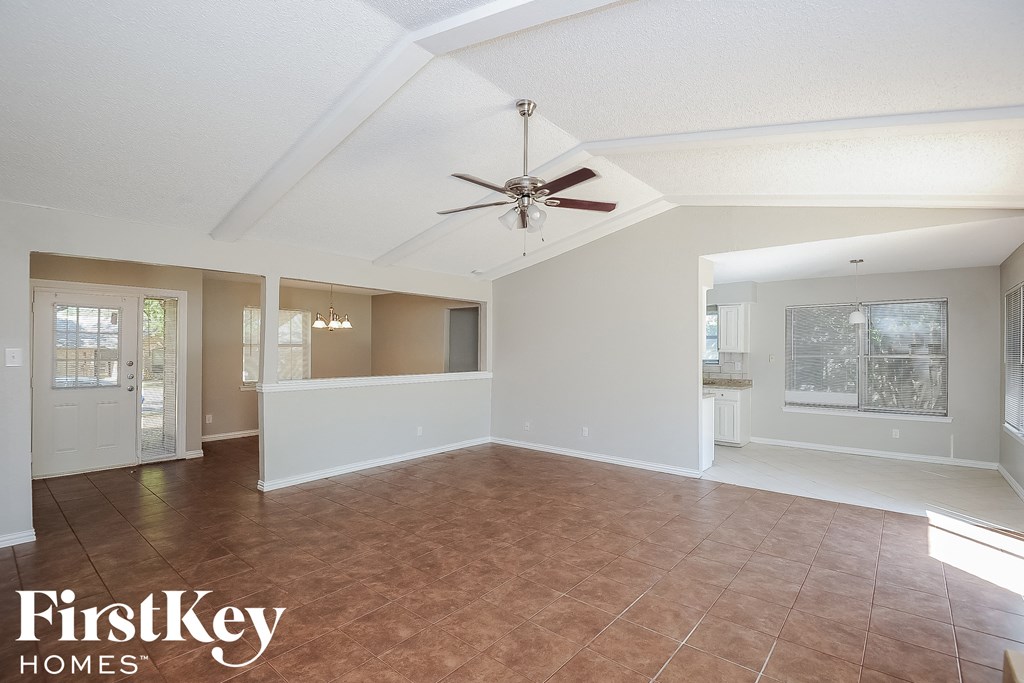 an empty living room with a ceiling fan