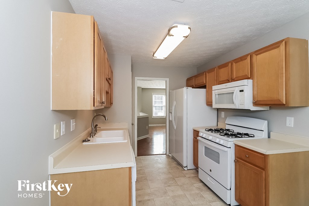 A kitchen with wooden cabinets and white appliances.