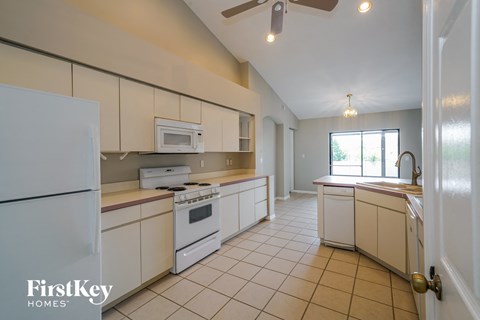 A kitchen with white appliances and a FirstKey Homes logo.