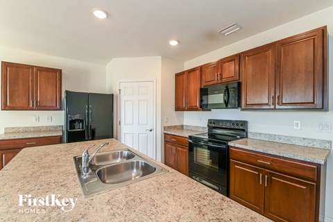 A kitchen with wooden cabinets and a granite countertop.