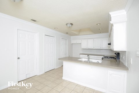 a white kitchen with white cabinets and a counter top