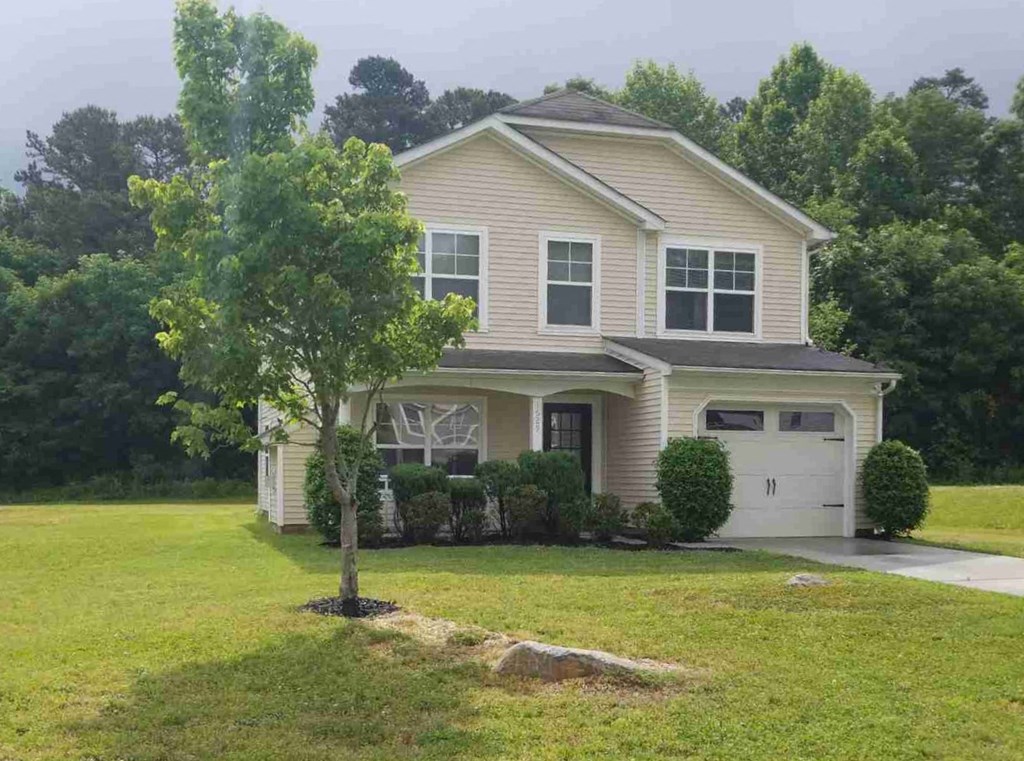 a house with a lawn and a tree in front of it
