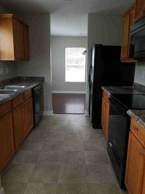 a kitchen with black appliances and wooden cabinets