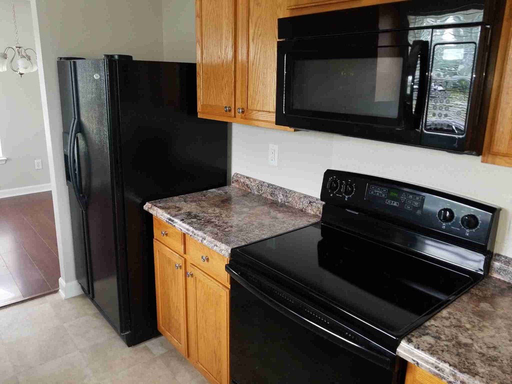 a kitchen with black appliances and granite counter tops