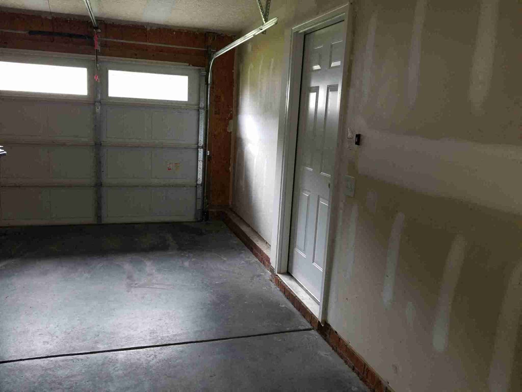 an empty garage with a door and a window