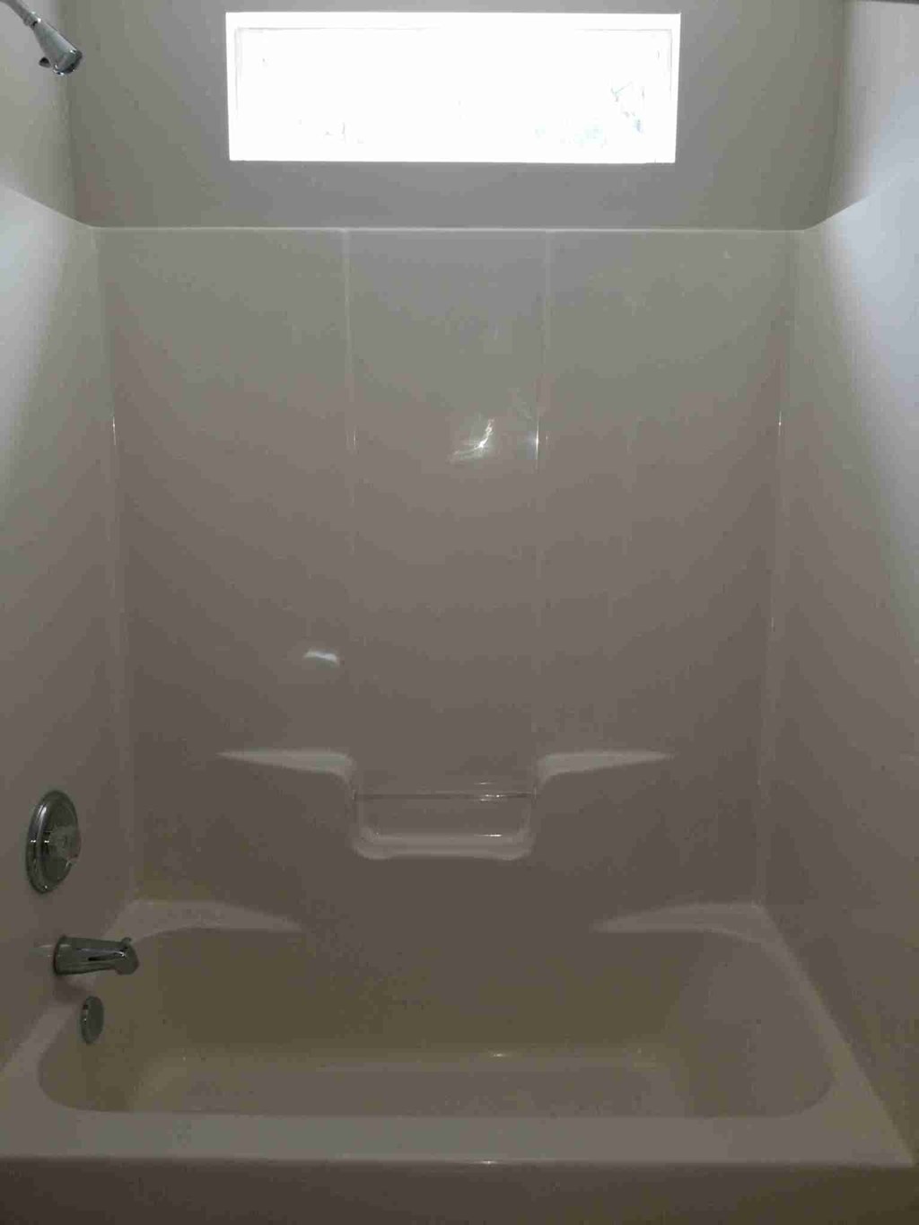 a small bathroom with a shower and a window