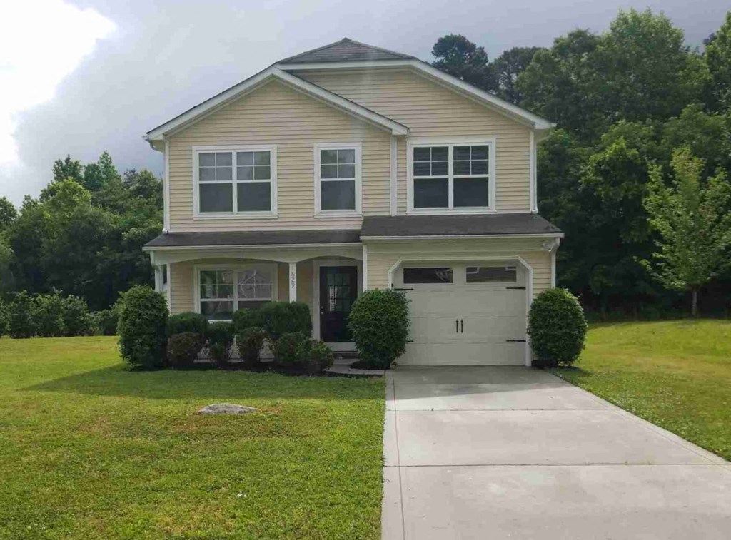 a house with a lawn and a sidewalk in front of it