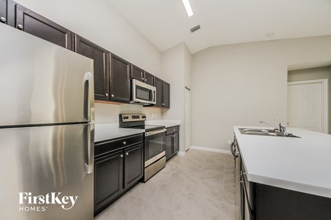 a modern kitchen with stainless steel appliances and black cabinets