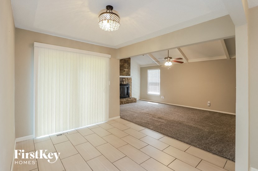 an empty living room with a sliding door to the dining room