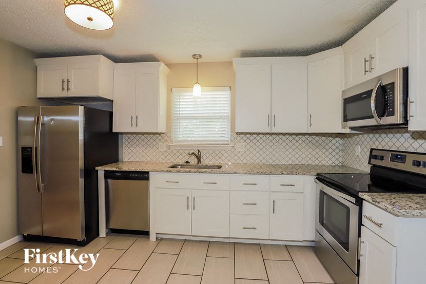 a kitchen with white cabinets and stainless steel appliances