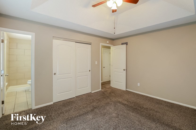 a master bedroom with two closets and a ceiling fan