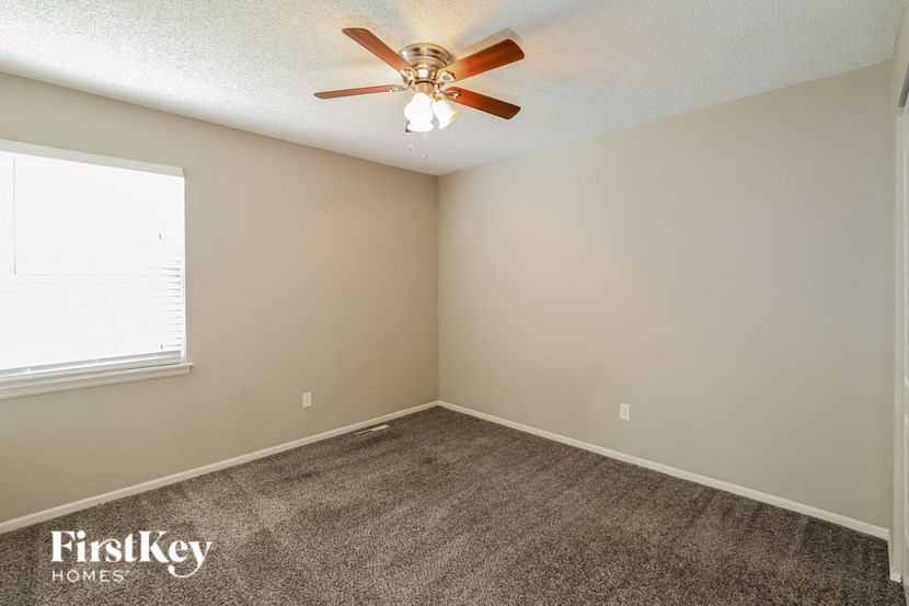 a bedroom with carpet and a ceiling fan