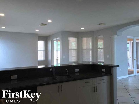 a kitchen with a black counter top and windows