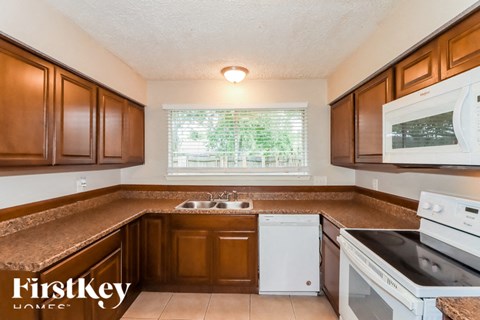 A kitchen with brown cabinets and a white dishwasher.